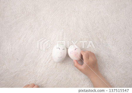 Child's hand holding a doodled egg Child's hand holding a doodled egg 137515547