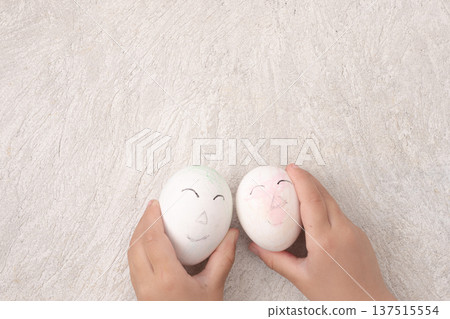 Child's hand holding a doodled egg Child's hand holding a doodled egg 137515554
