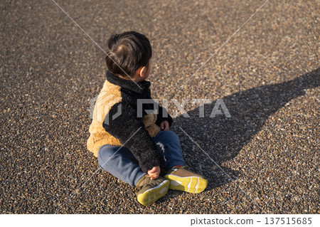 Toddler sitting on the side of the road Toddler sitting on the side of the road 137515685