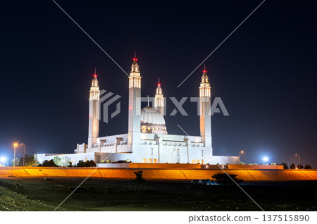 The illuminated Sultan Qaboos Mosque in Nizwa, Oman, showcasing grand Islamic architecture against a night sky. 137515890