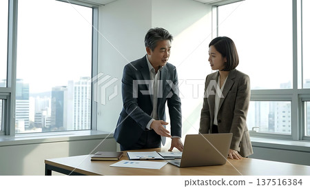 Experienced Korean Manager Mentoring Female Colleague in High-Rise Office 137516384