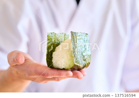 A chef wrapping seaweed around rice balls 137516594