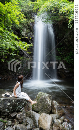 Woman staring at the waterfall Woman staring at the waterfall 137516931