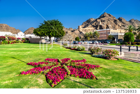 Scenic view of the lush gardens, flower beds, and ancient fort fortifications surrounding the Al Alam Palace in Muscat, Oman. Scenic view of the lush gardens, flower beds, and ancient fort fortifications surrounding the Al Alam Palace in Muscat, Oman. 137516933