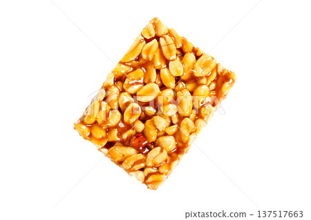 A piece of Brazilian peanut brittle made with roasted peanuts and shiny caramel, isolated on a white background. A typical Brazilian sweet A piece of Brazilian peanut brittle made with roasted peanuts and shiny caramel, isolated on a white background. A typical Brazilian sweet 137517663
