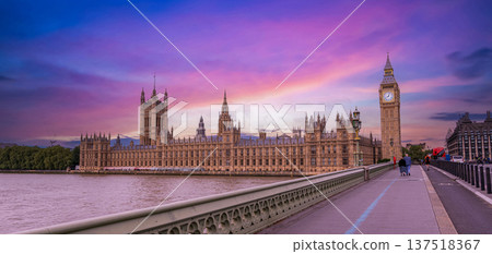 Twilight view of the London skyline showing the Palace of Westminster and Big Ben illuminated beside the River Thames under a vibrant purple pink and blue evening sky. Twilight view of the London skyline showing the Palace of Westminster and Big Ben illuminated beside the River Thames under a vibrant purple pink and blue evening sky. 137518367