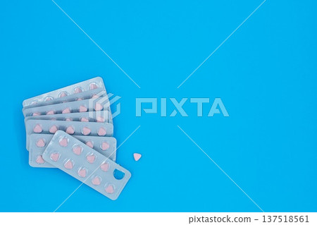 Medication Triangle Pink Pills in Aluminum Foil Packaging Blue Background Copy Space top And Right Side Medication Triangle Pink Pills in Aluminum Foil Packaging Blue Background Copy Space top And Right Side 137518561