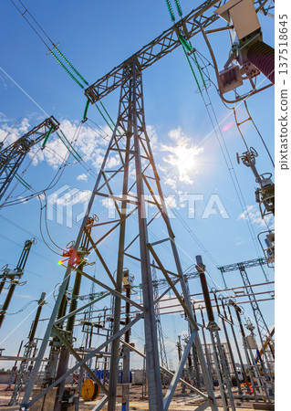 Vertical view of an outdoor electrical distribution substation, without people, at daytime on a background of a clear blue sky Vertical view of an outdoor electrical distribution substation, without people, at daytime on a background of a clear blue sky 137518645