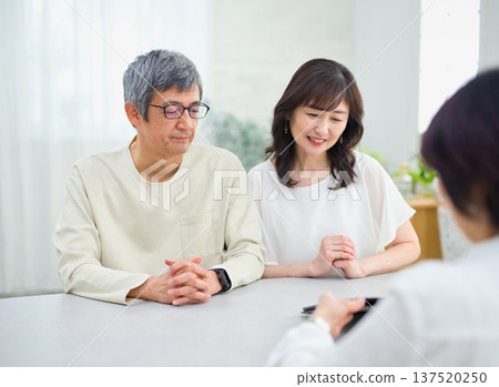 一位女銷售員正在向一對夫婦講解如何使用平板電腦 一位女銷售員正在向一對夫婦講解如何使用平板電腦 137520250