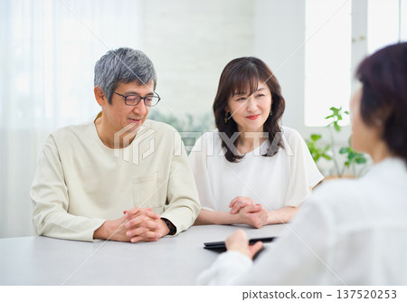 A saleswoman explaining to a couple using a tablet A saleswoman explaining to a couple using a tablet 137520253