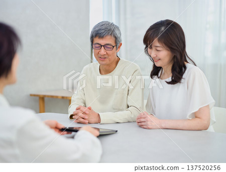 一位女銷售員正在向一對夫婦講解如何使用平板電腦 137520256