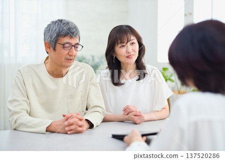 一位女銷售員正在向一對夫婦講解如何使用平板電腦 一位女銷售員正在向一對夫婦講解如何使用平板電腦 137520286