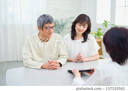 一位女銷售員正在向一對夫婦講解如何使用平板電腦 一位女銷售員正在向一對夫婦講解如何使用平板電腦 137520562