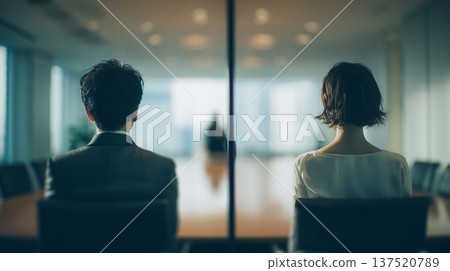 Two people facing each other through a glass window during a business negotiation 137520789