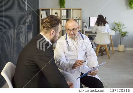 Doctor and patient reviewing results and diagnosis in modern medical office 137520816