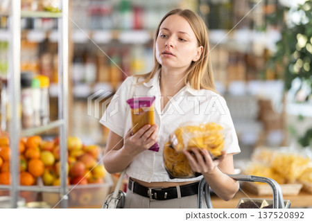 Young woman choosing pasta in grocery store Young woman choosing pasta in grocery store 137520892