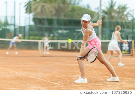 Woman playing tennis against female opponent on tennis court 137520920