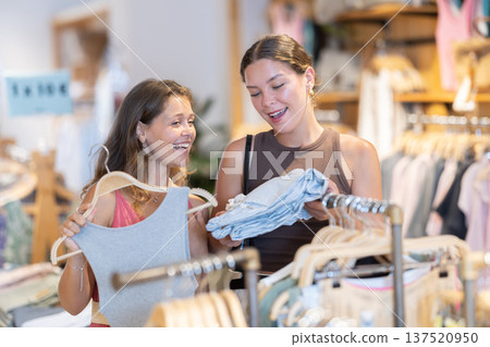 Two positive girls are buying clothes in store 137520950
