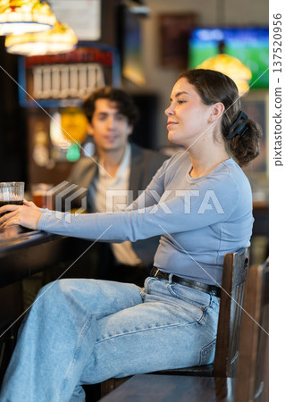 Young woman drinks beer at bar 137520956