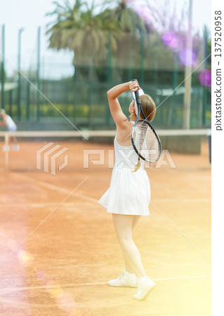 Woman playing tennis against female opponent on tennis court Woman playing tennis against female opponent on tennis court 137520958