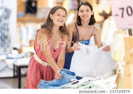 Two girls customer chooses shorts in store 137520974