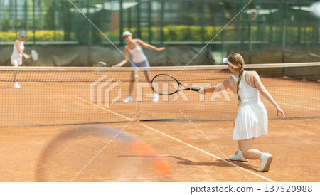 Concentrated sporty girl with tennis racquet and ball in her hands standing and ready to play match standing 137520988