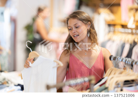Young woman choosing blouse in clothing store Young woman choosing blouse in clothing store 137521006
