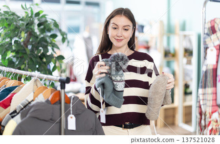Female shopper chooses a hat in clothing store 137521028