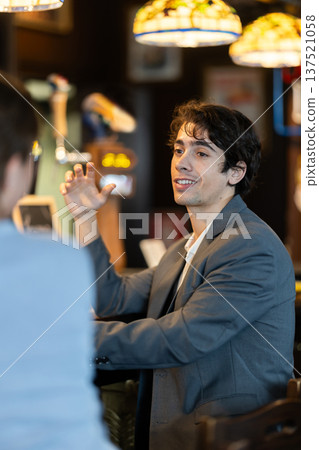 Man flirting with woman, they smile at each other Man flirting with woman, they smile at each other 137521058