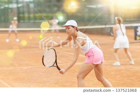 Woman playing tennis against female opponent on tennis court 137521068