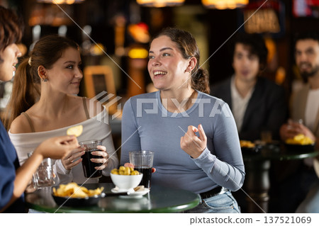 Happy women friends have fun and drinking beer on party in bar Happy women friends have fun and drinking beer on party in bar 137521069