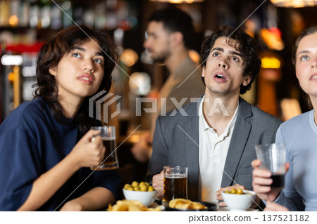 Group of emotional friends watch a sports match with interest in bar Group of emotional friends watch a sports match with interest in bar 137521182