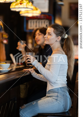 Young woman drinks beer at bar Young woman drinks beer at bar 137521197