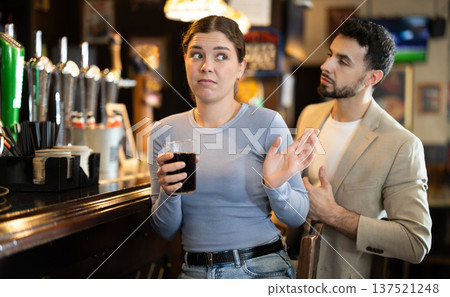 Young man flirting with woman getting rejected at bar Young man flirting with woman getting rejected at bar 137521248