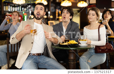 Extremely happy men and women supporters screaming and celebrating victory while drinking beer and watching tournament in bar Extremely happy men and women supporters screaming and celebrating victory while drinking beer and watching tournament in bar 137521317