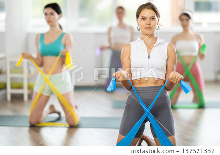 Group of young women doing pilates with band Group of young women doing pilates with band 137521332