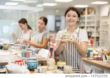 Young girl with handmade ceramic cup in workshop Young girl with handmade ceramic cup in workshop 137521359