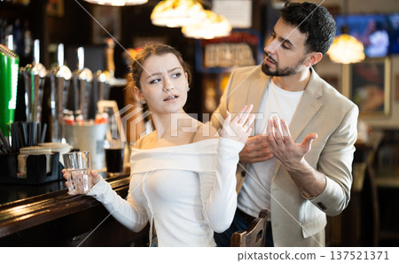 Young man flirting with woman getting rejected at bar 137521371