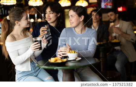 Happy women friends have fun and drinking beer on party in bar 137521382