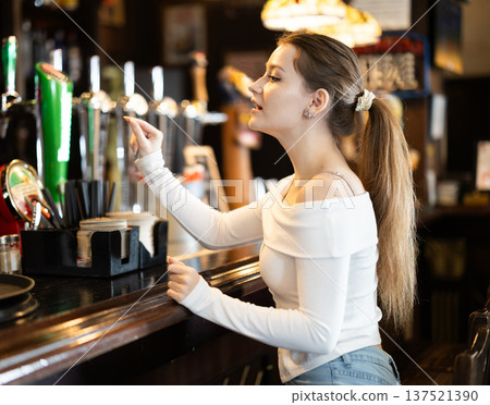 Young woman ordering at bar counter 137521390