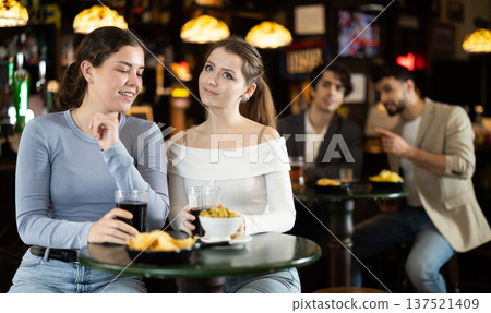 Two young women chatting and drinking beer at bar Two young women chatting and drinking beer at bar 137521409