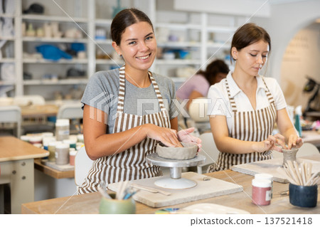 Woman teacher and student sculpt ceramic products 137521418