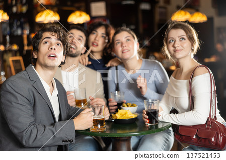 group of friends watching a game in a sports bar 137521453