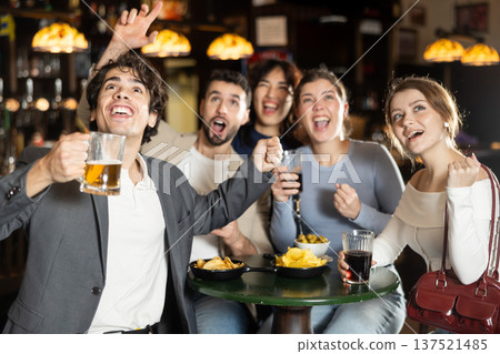Group of friends celebrating team victory while watching sports match Group of friends celebrating team victory while watching sports match 137521485