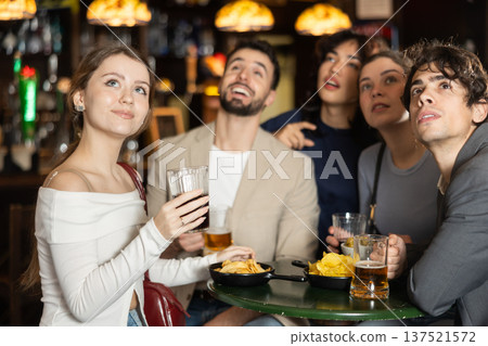 Group of friends watching sports match at bar Group of friends watching sports match at bar 137521572