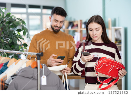 couple chooses a handbag together and scans the barcode on the mobile camera 137521580