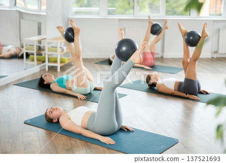 Group of young women doing pilates with softball Group of young women doing pilates with softball 137521693