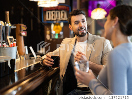 Man flirting with woman, they smile at each other Man flirting with woman, they smile at each other 137521715