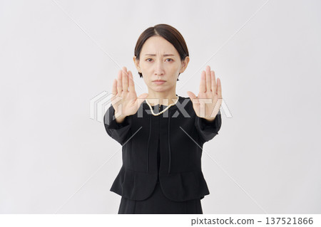 Woman in mourning clothes making a forbidden gesture on a white background 137521866