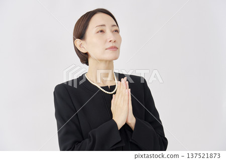 Woman in mourning clothes, hands together in prayer, white background Woman in mourning clothes, hands together in prayer, white background 137521873